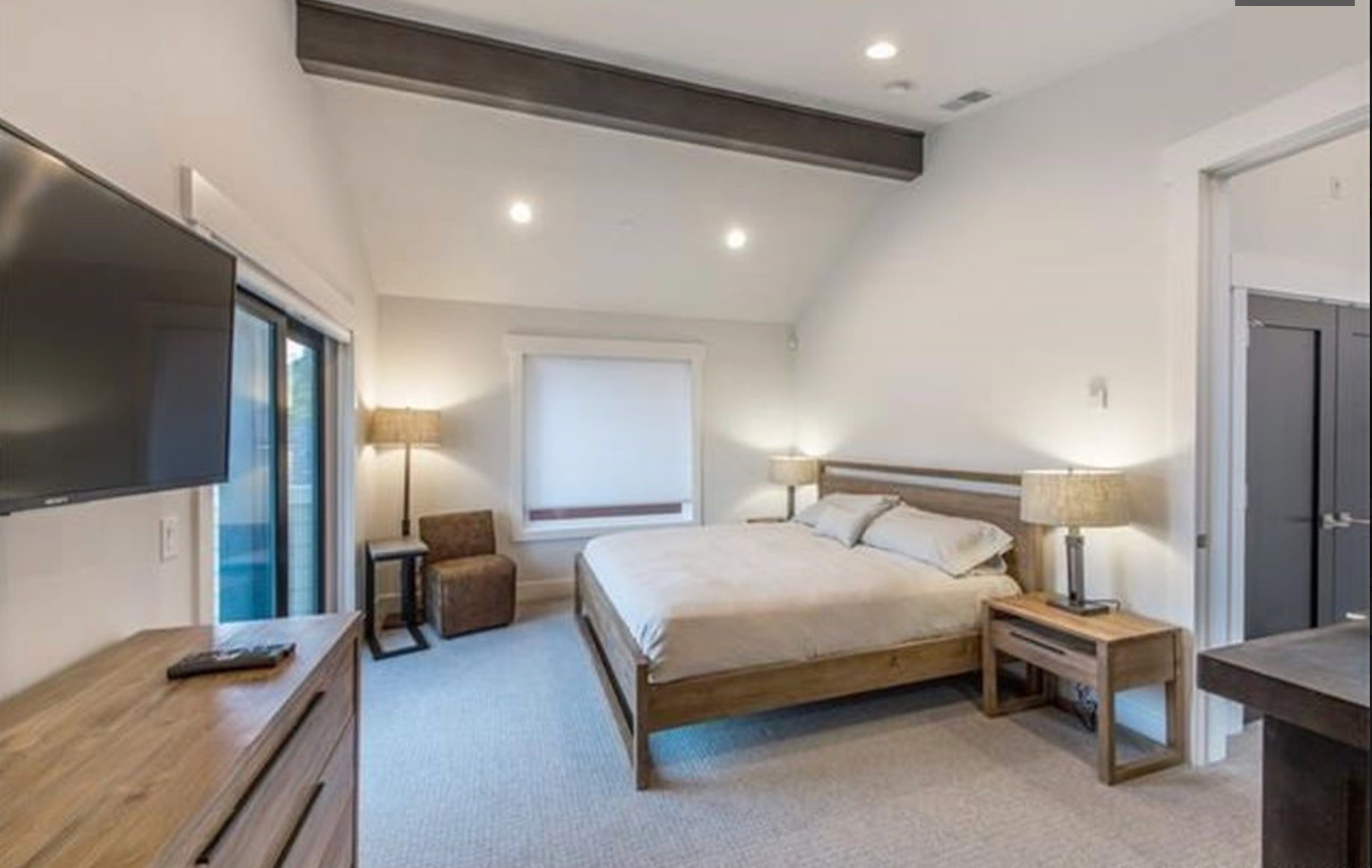 Third bedroom — king bed, dark beam, sliding door to deck