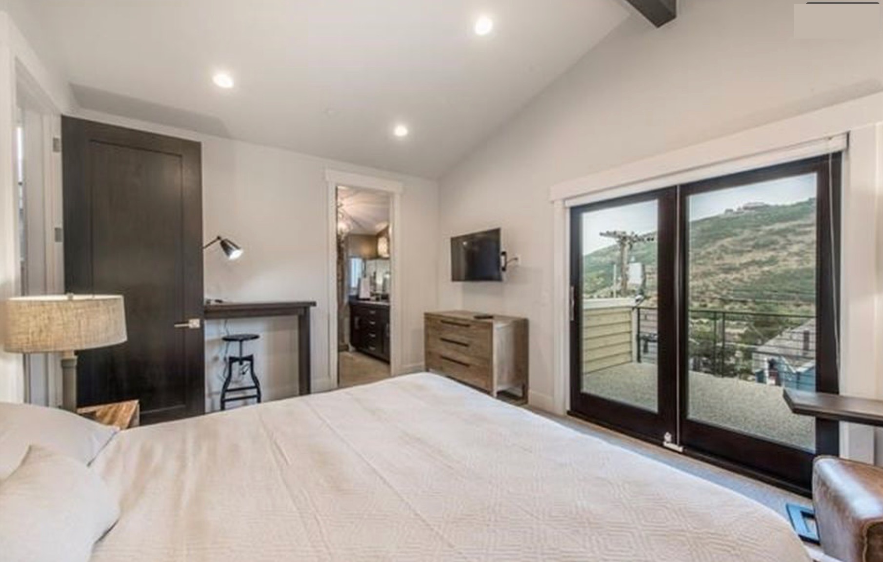 Master bedroom — sliding doors to private deck with mountain view