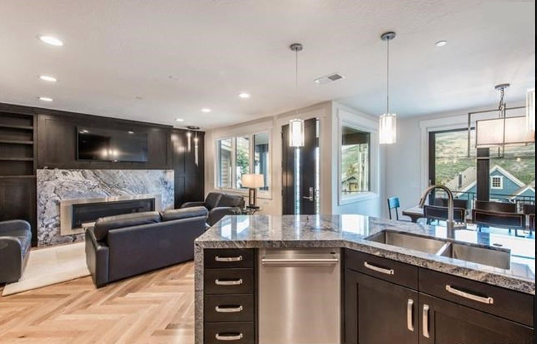 Open living room and kitchen with marble fireplace surround