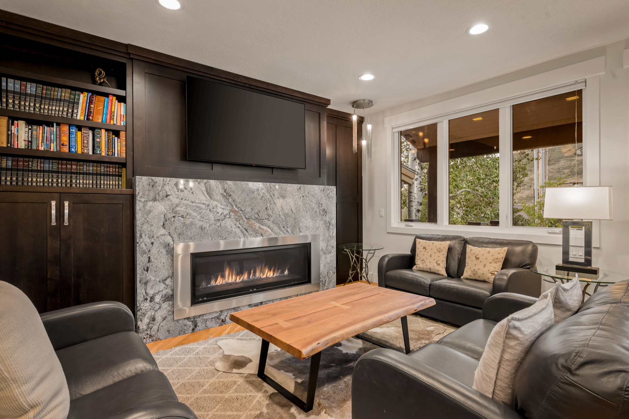 Library with marble fireplace and built-in bookshelves