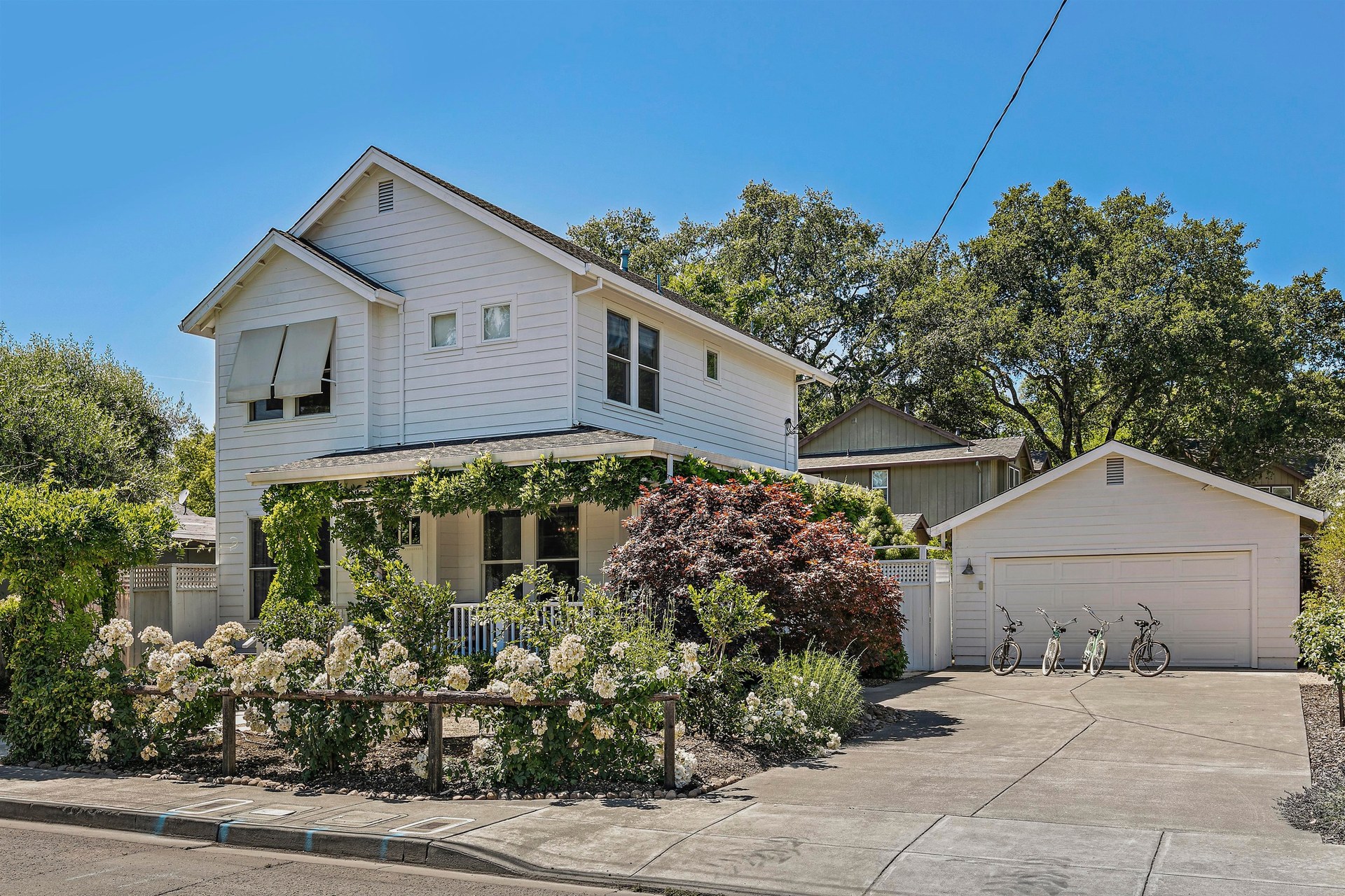 The home from the street — wisteria porch, picket fence